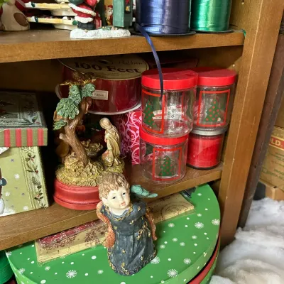 Sale Photo Thumbnail #300: Collection of holiday decorations, including small figurines, Christmas tree jars, spools of ribbon, and festive gift boxes.