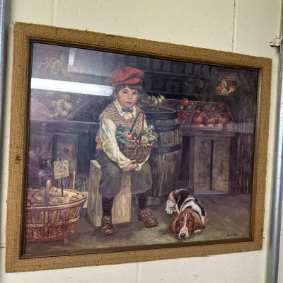 Sale Photo Thumbnail #125: Framed vintage art print by Lee Dubin depicting a boy with a basket of produce and a basset hound, housed in a wooden frame with a burlap liner.