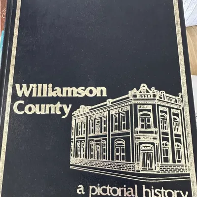 Sale Photo Thumbnail #424: Hardcover edition of "Williamson County: A Pictorial History" featuring gold-foil lettering and architectural illustration on a black cover.