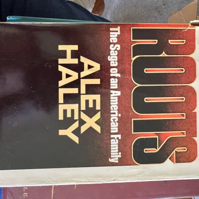 Sale Photo Thumbnail #459: Hardcover copy of 'Roots: The Saga of an American Family' by Alex Haley with dust jacket, showing wear along the edges.
