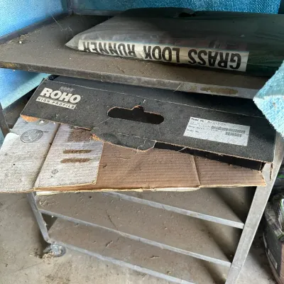 Sale Photo Thumbnail #724: Multi-tier metal rolling utility cart holding a packaged artificial grass runner and a Roho cushion box.