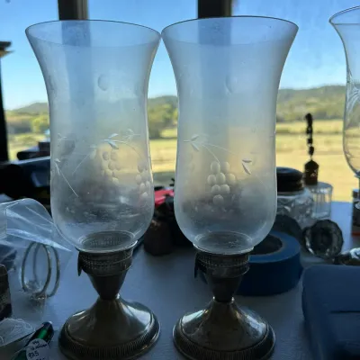 Sale Photo Thumbnail #394: Pair of vintage silver-plated hurricane lamps featuring etched glass shades with a grape and leaf motif.