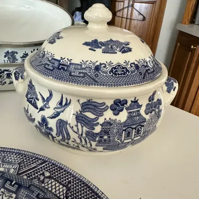 Sale Photo Thumbnail #708: Vintage Blue Willow pattern covered soup tureen with matching handles, shown with additional enamelware pieces.