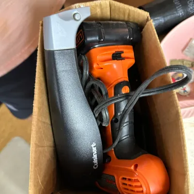 Sale Photo Thumbnail #12: Black & Decker cordless power tool handle alongside a Cuisinart accessory, packed together in a cardboard box.