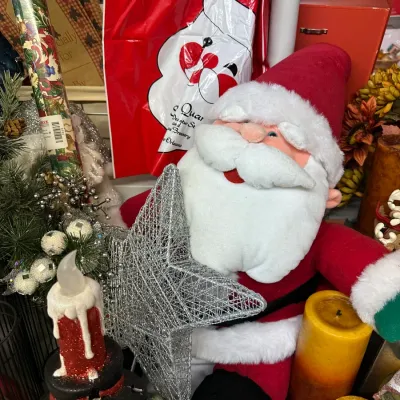 Sale Photo Thumbnail #21: Vintage plush Santa Claus figure displayed alongside holiday decor, including a silver mesh star tree topper, a snowman candle holder, and a festive red Santa bag.