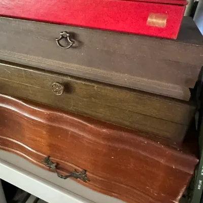 Sale Photo Thumbnail #239: Stack of vintage wooden silverware chests and presentation boxes in varying finishes and styles, showing light surface wear.