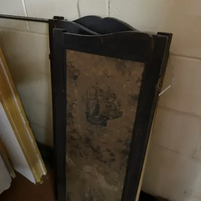 Sale Photo Thumbnail #285: Vintage three-panel folding room divider with dark wooden frame and nautical ship prints on textured panels.
