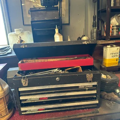 Sale Photo Thumbnail #746: Craftsman Rally Box black metal portable tool chest with three drawers and a top lift compartment filled with hand tools.