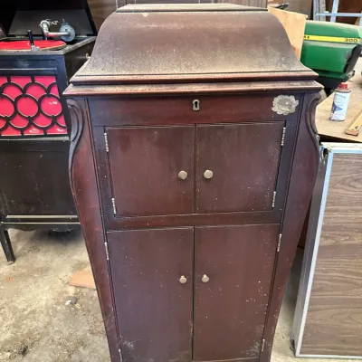 Sale Photo Thumbnail #524: Vintage floor-standing phonograph cabinet in dark stained wood, featuring double storage doors and cabriole legs.