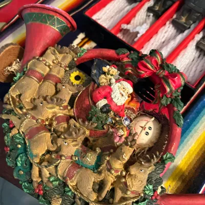 Sale Photo Thumbnail #370: Festive Christmas-themed decorative watering can featuring painted resin reliefs of Santa Claus, reindeer, and holiday foliage.