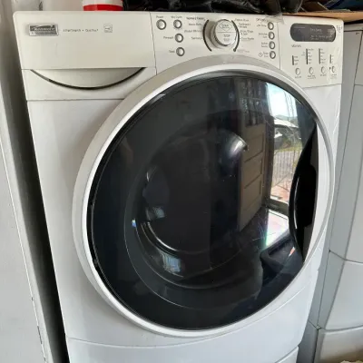 Sale Photo Thumbnail #154: Kenmore Elite front-load washing machine in white, featuring SmartWash and QuietPak4 technology with a digital cycle selection panel.