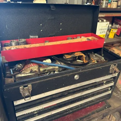 Sale Photo Thumbnail #490: Vintage black metal Craftsman portable tool box with multiple drawers and a removable red top tray filled with various tools, sockets, and hardware.