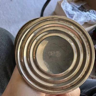 Sale Photo Thumbnail #388: Underside of a weighted sterling silver candlestick or goblet base, showing manufacturer hallmarks and stamped lettering.