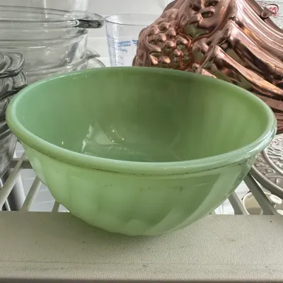 Sale Photo Thumbnail #687: Vintage Fire-King jadeite green glass mixing bowl with ribbed exterior, displayed alongside glass bake ware and a copper mold.