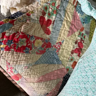 Sale Photo Thumbnail #356: Handmade vintage patchwork quilt featuring a variety of colorful floral, polka dot, and striped fabric scraps with dense hand-stitching.