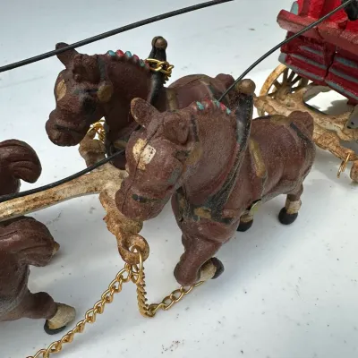 Sale Photo Thumbnail #173: Vintage cast iron horse-drawn stagecoach toy featuring painted brown horses with harness details and brass chain reins.