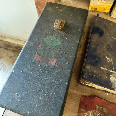Sale Photo Thumbnail #478: Vintage Emergox emergency oxygen carrying case, featuring a textured dark metal body with a brass latch and original decal.