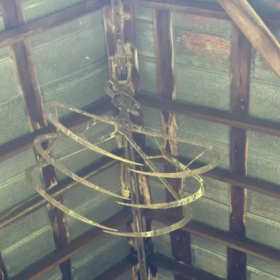 Sale Photo Thumbnail #758: Vintage iron hay grapple trolley suspended from a barn ceiling track.