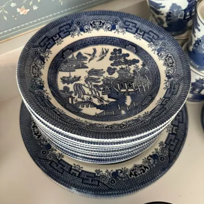 Sale Photo Thumbnail #698: Stack of vintage Blue Willow pattern transferware plates and matching teacups.
