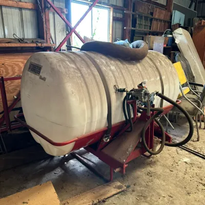 Sale Photo Thumbnail #553: Large white poly liquid storage and sprayer tank mounted on a red metal frame, labeled Tractor Supply Co.