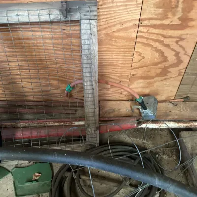 Sale Photo Thumbnail #344: Assorted farm and workshop supplies, including wire mesh framed screens, flexible tubing, and an electric fence energizer.