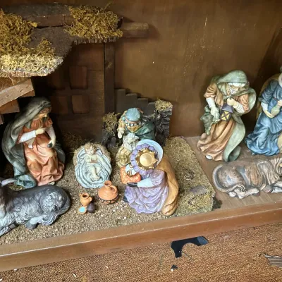 Sale Photo Thumbnail #75: Vintage painted nativity set displayed inside a wooden stable frame, featuring figurines of the Holy Family, wise men, shepherd, and animals.