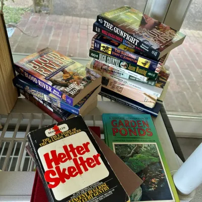Sale Photo Thumbnail #264: Collection of vintage paperback and hardcover books, including western novels and true crime titles like Helter Skelter.
