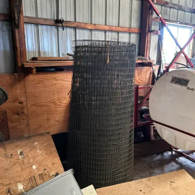 Sale Photo Thumbnail #551: Large roll of galvanized wire mesh fencing stored inside a shed.