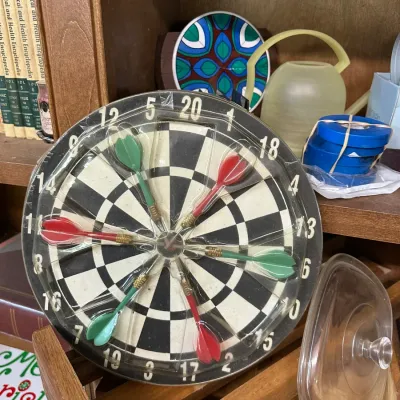 Sale Photo Thumbnail #63: Vintage miniature dartboard set with six plastic darts, sealed in original packaging.