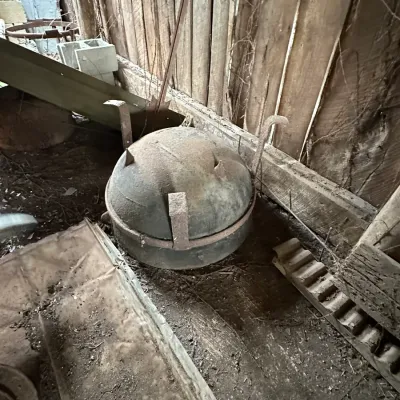 Sale Photo Thumbnail #335: Vintage heavy cast iron cooking pot or wash cauldron with a domed lid and metal bracket arms, showing a heavily weathered, rusted patina.