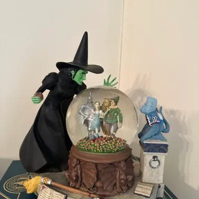 Sale Photo Thumbnail #684: The Wizard of Oz collectible snow globe featuring the Wicked Witch of the West, Winged Monkey, and main characters inside the globe.