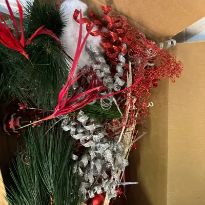 Sale Photo Thumbnail #53: Cardboard box filled with sorted holiday decor picks, including faux pine greenery, red mesh leaves, and glittery silver and red curly spray picks.