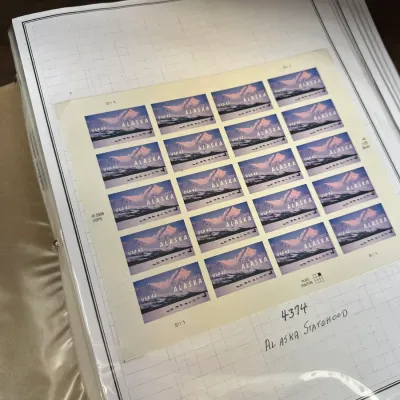 Sale Photo Thumbnail #112: Full sheet of 2008 USPS 42-cent Alaska Statehood stamps mounted in a stamp collector's album.