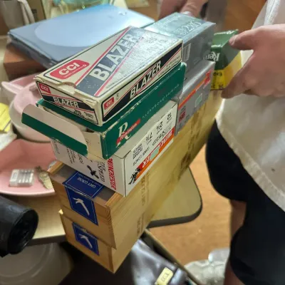 Sale Photo Thumbnail #223: Stack of vintage ammunition boxes including CCI Blazer, Remington Kleanbore, and Winchester Super Speed game loads, perched atop Grey Goose wooden crates.