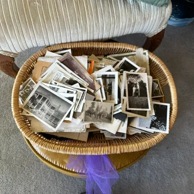 Sale Photo Thumbnail #381: Large collection of vintage black-and-white photographs and postcards filled in a woven basket.