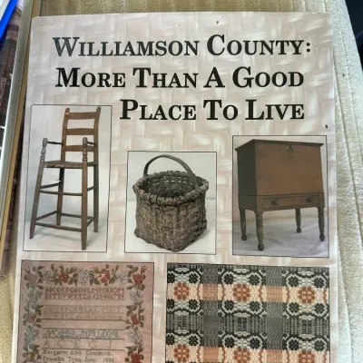 Sale Photo Thumbnail #426: Softcover book titled "Williamson County: More Than A Good Place To Live" by Rick Warwick, featuring illustrations of local antiques and textiles on the front cover.