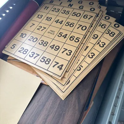 Sale Photo Thumbnail #716: Stack of vintage paper bingo cards stored inside a metal file drawer.
