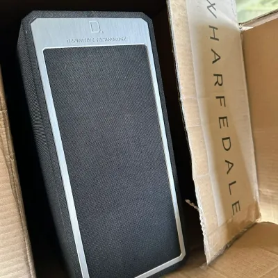 Sale Photo Thumbnail #148: Definitive Technology Demand Series bookshelf speaker in black fabric and brushed aluminum trim, stored inside a cardboard box.