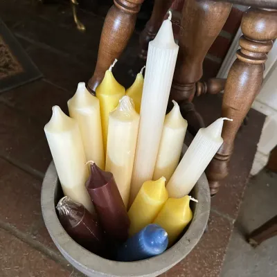 Sale Photo Thumbnail #651: Collection of assorted pillar and taper candles in various colors, arranged inside a ceramic crock.