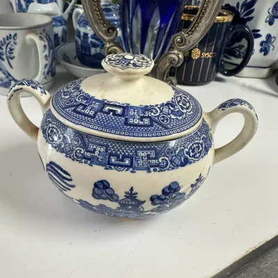 Sale Photo Thumbnail #705: Vintage double-handled blue and white transferware sugar bowl with lid, featuring a Blue Willow pattern.
