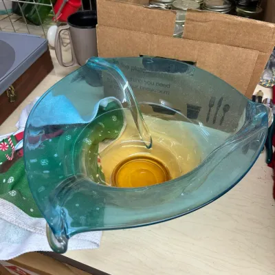 Sale Photo Thumbnail #8: Mid-century Blenko-style teal blue art glass chip and dip bowl set featuring a smaller amber glass insert bowl resting inside the larger handles.