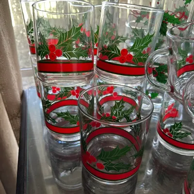 Sale Photo Thumbnail #466: Set of vintage holiday glassware including highball glasses, rocks glasses, and mugs, featuring a holly leaves and red berries motif with red banding.