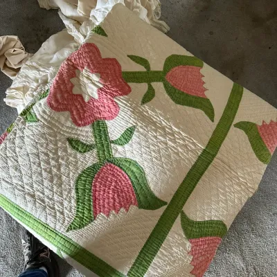 Sale Photo Thumbnail #352: Handmade applique quilt featuring a pink floral motif with green stems and leaves, finely quilted on a white background.