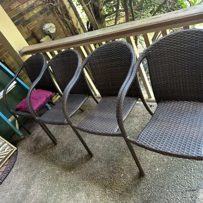 Sale Photo Thumbnail #185: Set of four dark brown resin wicker patio armchairs lined up on a covered porch.