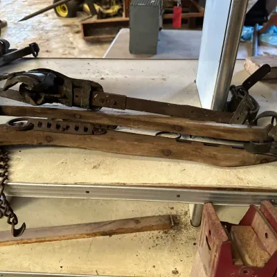 Sale Photo Thumbnail #215: Antique wooden and iron horse harness hames featuring attached leather straps and metal chains.