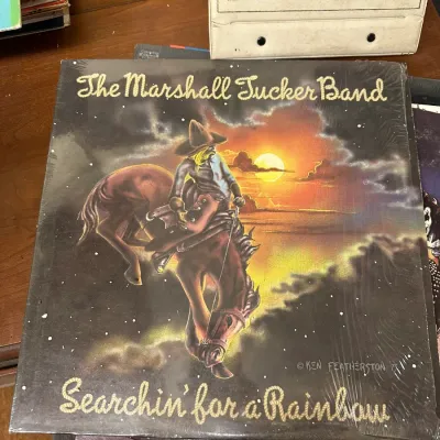 Sale Photo Thumbnail #132: The Marshall Tucker Band "Searchin' for a Rainbow" vinyl record album, released in 1975, preserved in its original shrink wrap.