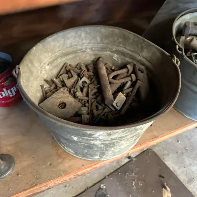 Sale Photo Thumbnail #504: Vintage galvanized metal bucket filled with assorted rusty hardware, bolts, and scrap metal pieces.