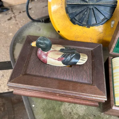 Sale Photo Thumbnail #157: Vintage wooden desk caddy or box featuring a carved mallard duck handle on a framed faux-leather lid.