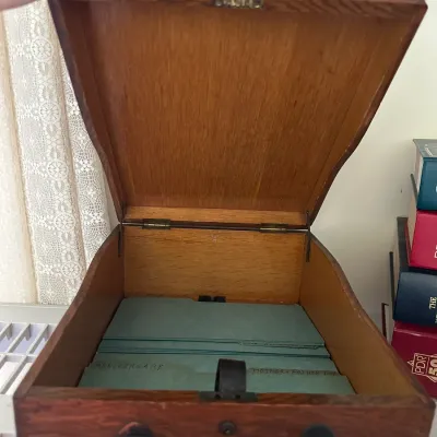 Sale Photo Thumbnail #413: Vintage oak card file box with a slant-top lid, front drop handle, and green category dividers.