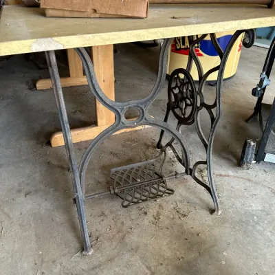 Sale Photo Thumbnail #725: Vintage treadle sewing machine cast iron base repurposed into a table with a light laminate top.